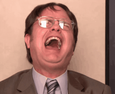 A Man With Glasses Is Laughing With His Mouth Open GIF