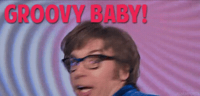 A Man With Glasses Is Making A Funny Face And The Words Groovy Baby Are Behind Him . GIF