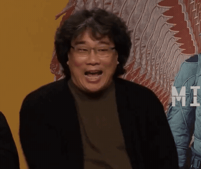 A Man With Glasses Is Making A Funny Face In Front Of A Poster That Says Mt. GIF