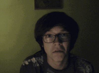 A Man With Glasses Is Pointing At The Camera And Smiling GIF