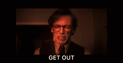 A Man With Glasses Is Screaming In A Dark Room With The Words Get Out Above Him GIF
