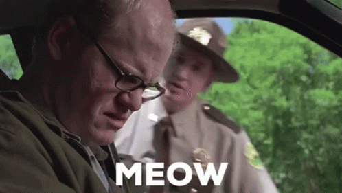A Man With Glasses Is Sitting In A Car Next To A Police Officer And The Word Meow Is On The Screen . GIF