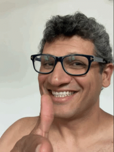 A Man With Glasses Is Smiling And Giving A Thumbs Up GIF