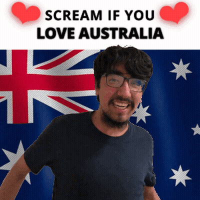 A Man With Glasses Is Smiling In Front Of An Australian Flag And A Sign That Says Scream If You Love Australia GIF