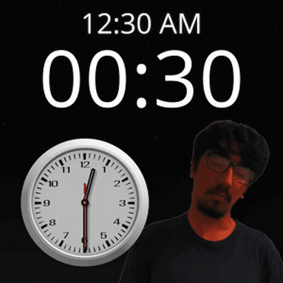 A Man With Glasses Is Standing In Front Of A Clock That Says 12:30 Am GIF