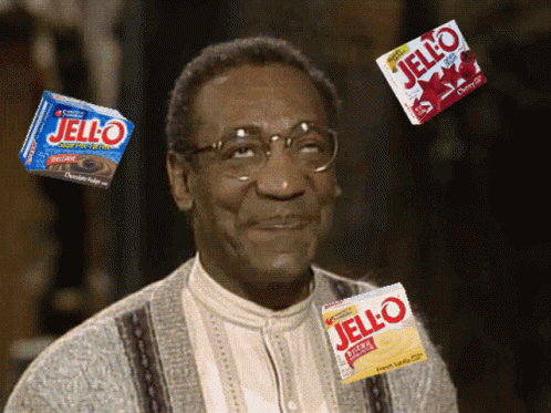 A Man With Glasses Is Surrounded By Jello Boxes GIF