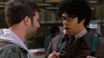 A Man With Glasses Is Talking To Another Man With A Surprised Look On His Face GIF