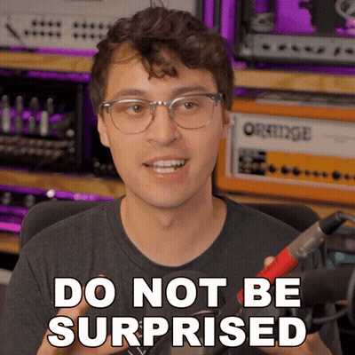 A Man With Glasses Says Do Not Be Surprised While Holding A Microphone GIF