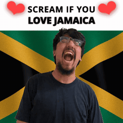 A Man With Glasses Screams In Front Of A Jamaican Flag GIF