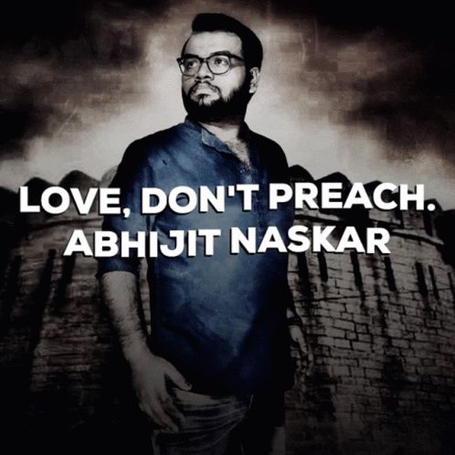 A Man With Glasses Stands In Front Of A Brick Wall With The Words Love Do N't Preach Abhijit Naskar GIF