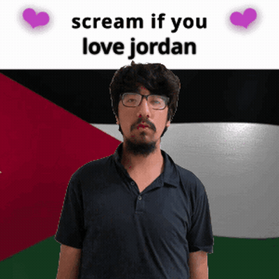 A Man With Glasses Stands In Front Of A Flag With The Words " Scream If You Love Jordan " Above Him GIF