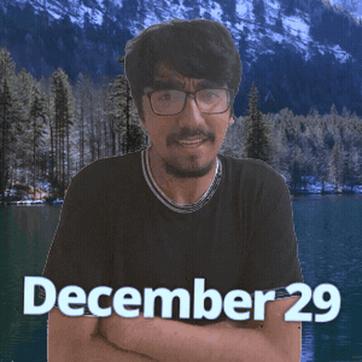 A Man With Glasses Stands In Front Of A Lake With The Date December 29 On The Bottom GIF
