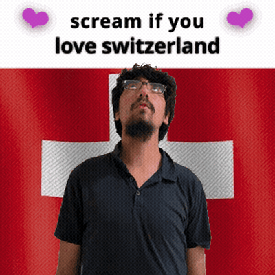 a man with glasses stands in front of a switzerland flag and says " scream if you love switzerland "
