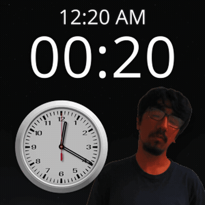 A Man With Glasses Stands Next To A Clock That Says 12:20 Am GIF