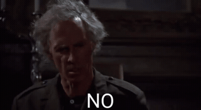 A Man With Gray Hair And A Black Jacket Is Standing In A Dark Room And Saying No . GIF