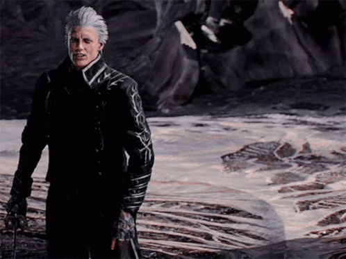 A Man With Gray Hair And A Black Jacket Stands In Front Of A Body Of Water GIF