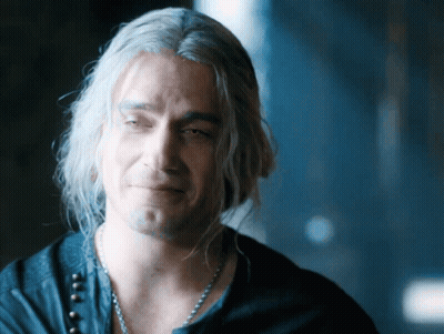 A Man With Gray Hair And A Necklace Looks Down GIF