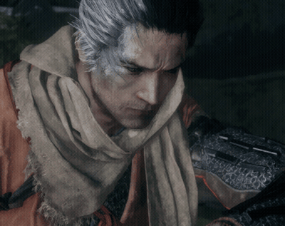A Man With Gray Hair And A Scarf Around His Neck Looks At Something GIF