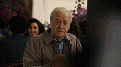 A Man With Gray Hair Is Sitting In Front Of A Window GIF