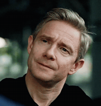 A Man With Gray Hair Is Wearing A Black Shirt And Smiling GIF