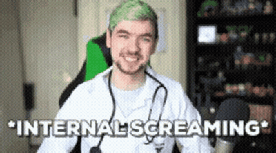 A Man With Green Hair And A Stethoscope Around His Neck Is Sitting In A Chair . GIF