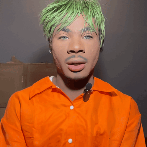 A Man With Green Hair And An Orange Shirt GIF