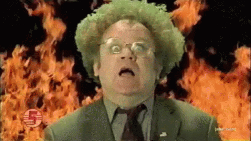 A Man With Green Hair And Glasses Is Standing In Front Of A Fire GIF