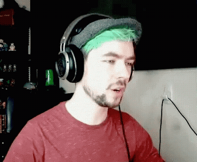 A Man With Green Hair Is Wearing Headphones And A Hat GIF