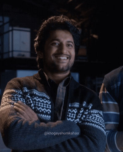 A Man With His Arms Crossed Is Wearing A Sweater With A Pattern On It GIF