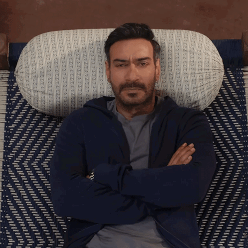 A Man With His Arms Crossed Laying On A Bed GIF