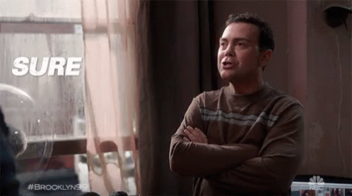 A Man With His Arms Crossed Stands In Front Of A Window With The Words Sure Above Him GIF