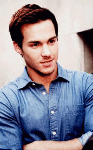 A Man With His Arms Crossed Wearing A Blue Shirt GIF