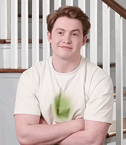 A Man With His Arms Crossed Wearing A Shirt That Says I Am Real GIF