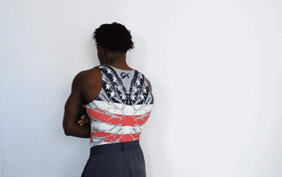 A Man With His Arms Crossed Wears A Tank Top With The Letter Gk On The Back GIF