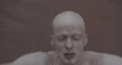 A Man With His Arms Outstretched Has A Tattoo On His Chest That Says ' I ' GIF