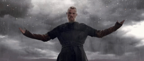 A Man With His Arms Outstretched Standing In The Rain GIF