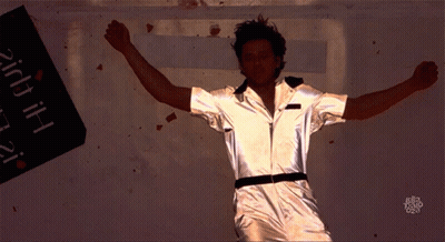 A Man With His Arms Outstretched Stands In Front Of A Sign That Says ' Hi ' GIF