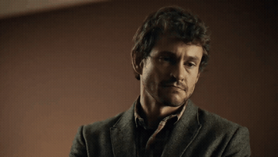 A Man With His Eyes Closed And A Beard Is Wearing A Grey Jacket GIF