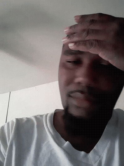 A Man With His Eyes Closed And His Hands On His Face GIF