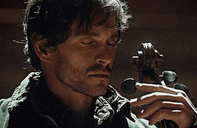 A Man With His Eyes Closed Is Holding A Violin In His Hands GIF