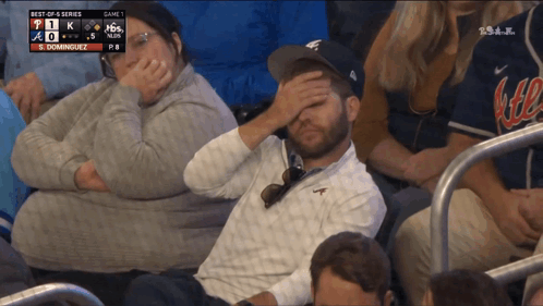 A Man With His Hand On His Forehead Is Watching A Baseball Game Between The Braves And The Dodgers GIF