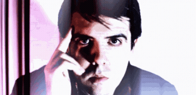 A Man With His Hand On His Forehead Looks At The Camera GIF