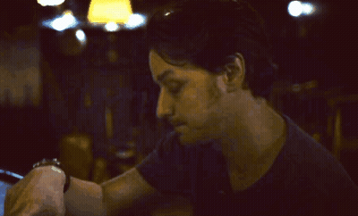 A Man With His Hand On His Forehead Looks Down GIF