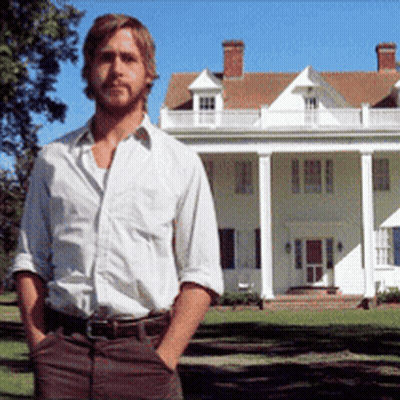 A Man With His Hands In His Pockets Stands In Front Of A Large White House GIF