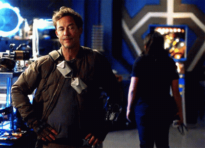 A Man With His Hands On His Hips Stands In Front Of A Woman GIF