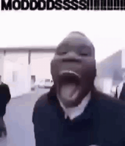 A Man With His Mouth Open And His Tongue Sticking Out Is Standing In Front Of A Building . GIF