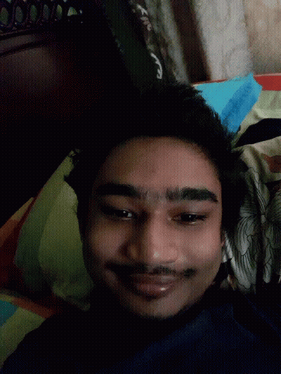 A Man With His Tongue Out Is Laying On A Bed GIF