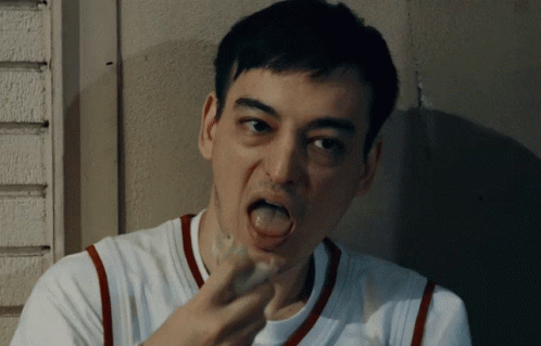 A Man With His Tongue Out Is Wearing A White And Red Shirt GIF