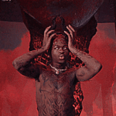 A Man With Horns And Wings Is Standing In Front Of A Large Skull GIF