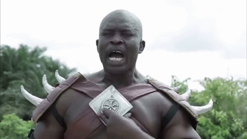 A Man With Horns On His Shoulders Is Holding A Wallet With A Cross On It GIF